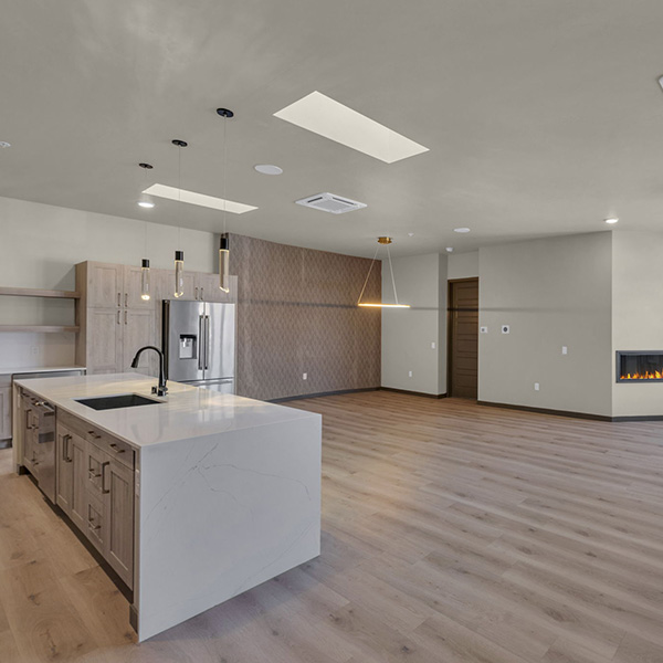 Double R penthouse living area with wood floor, modern kitchen, and fireplace.